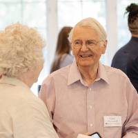 Gary Richmond smiling talking with woman at event
